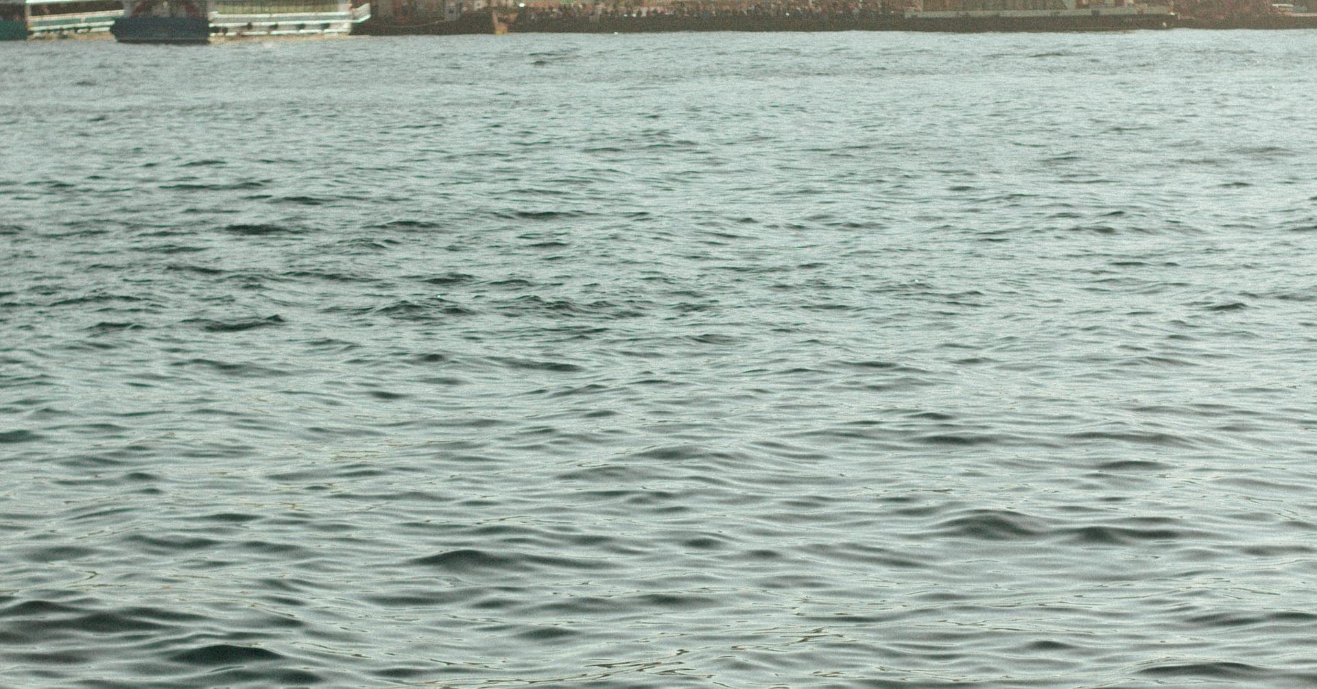 Haliç'te sakin su yüzeyi ve uzakta yanaşmış vapurlar